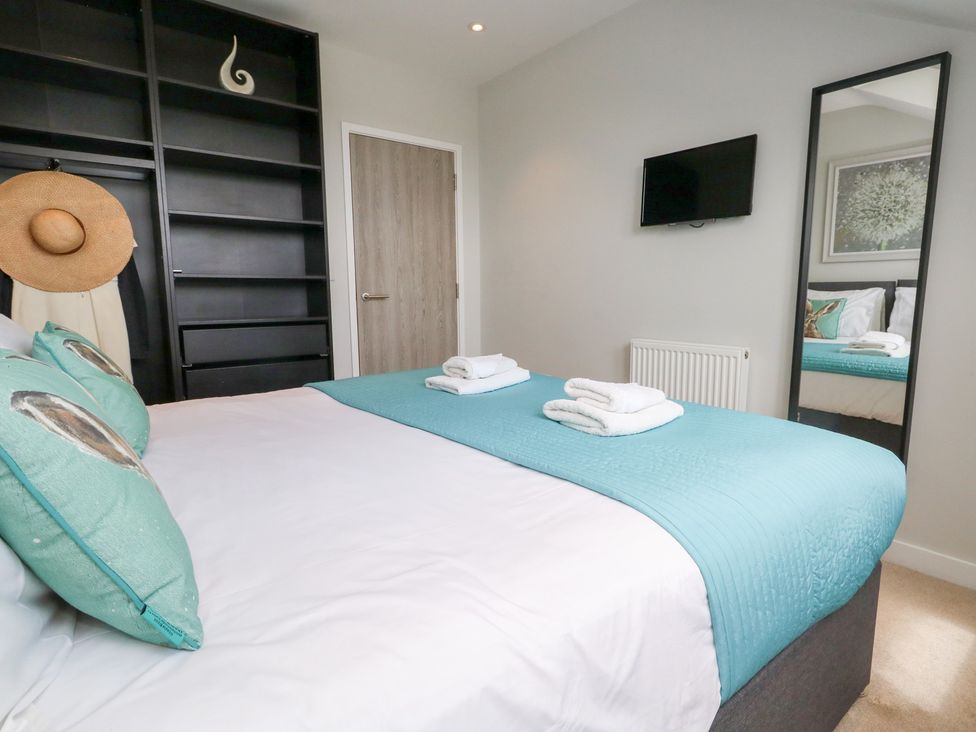 A bedroom with a bed and shelves at Corvesgate Nottington near Weymouth