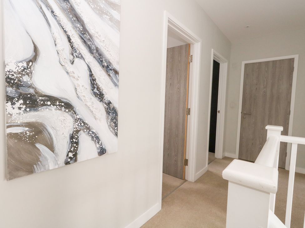 A hallway with doors and a painting at Corvesgate in Nottington near Weymouth