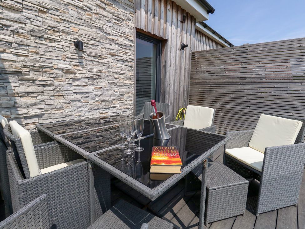 An outdoor seating area with a table and chairs at Corvesgate in Nottington near Weymouth