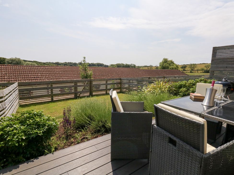 An outdoor area with a table and chairs at Corvesgate in Nottington near Weymouth