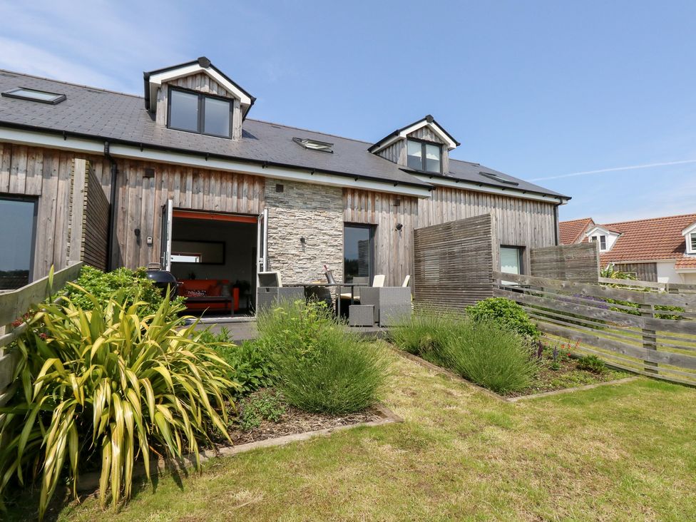A garden with outdoor furniture and a view of the building at Corvesgate Nottington near Weymouth