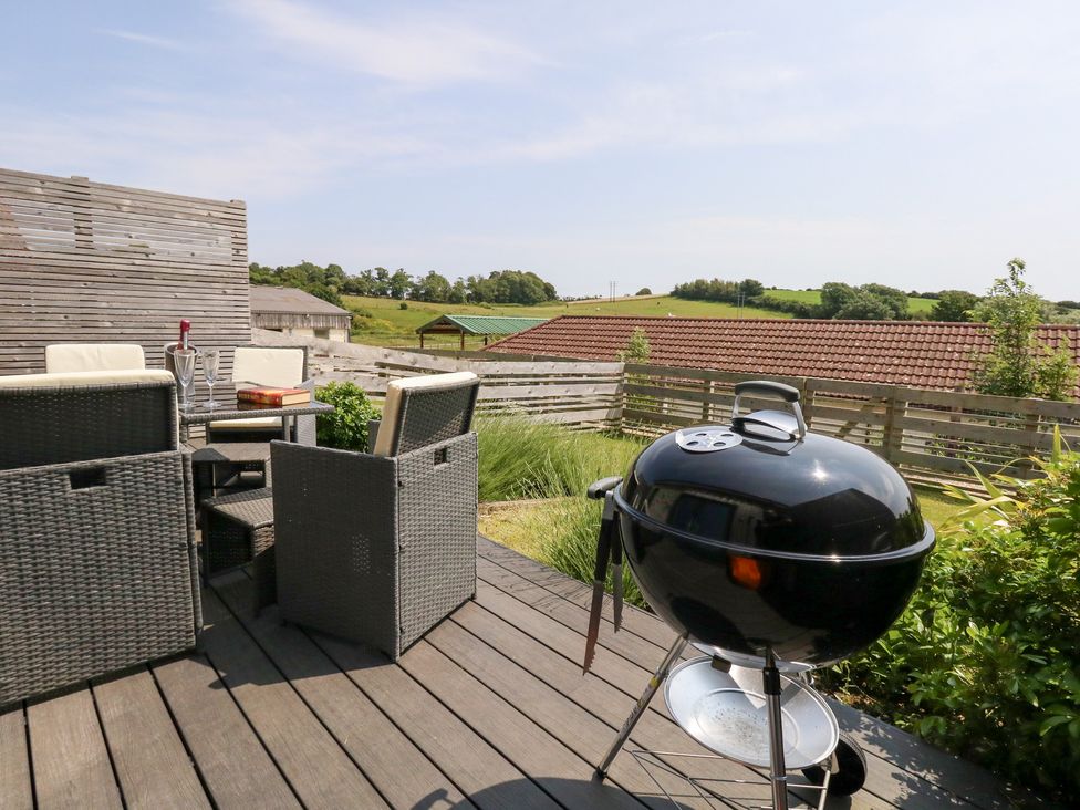 An outdoor area with chairs and a grill at Corvesgate Nottington near Weymouth