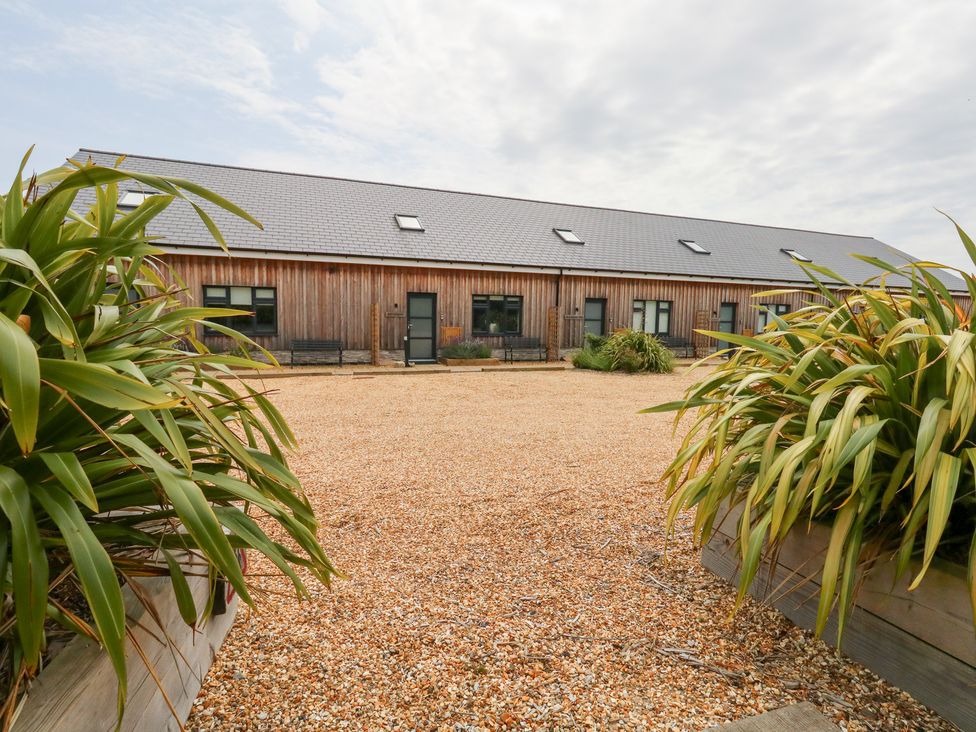 An outdoor property with a gravel area and wooden building at Corvesgate Nottington near Weymouth