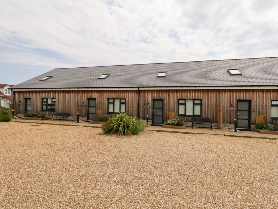 A wooden building with benches and gravel at Corvesgate in Nottington near Weymouth