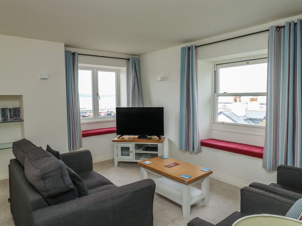 A living room with a television and a coffee table at Bay View in Brixham