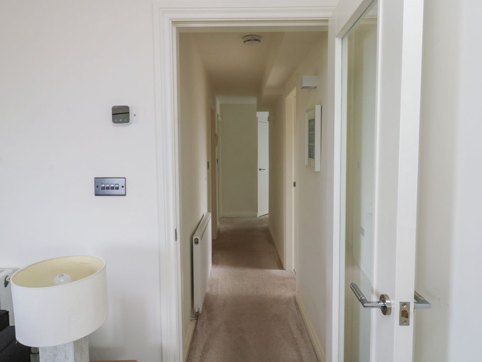 A hallway with a lamp and thermostat at Bay View in Brixham