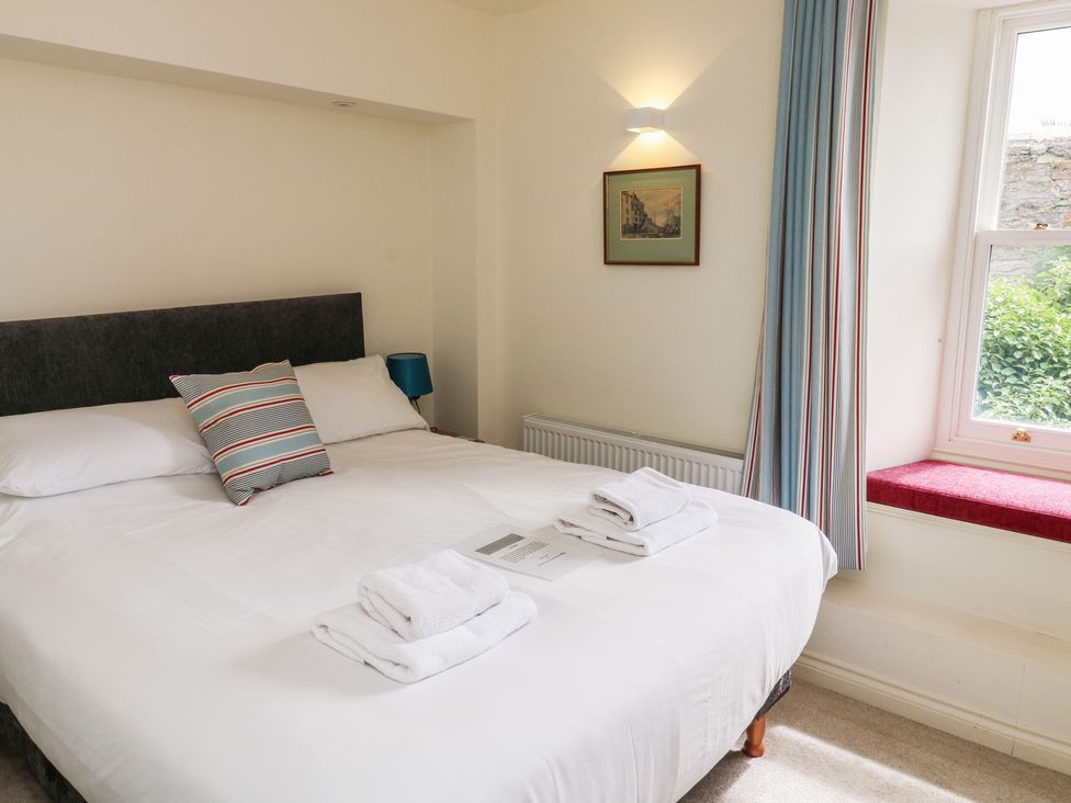 A bedroom with a bed and window at Bay View in Brixham