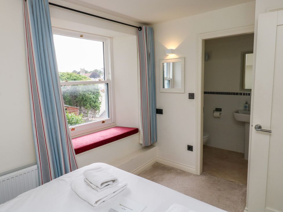 A bedroom with a window, bed, and door to bathroom at Bay View in Brixham