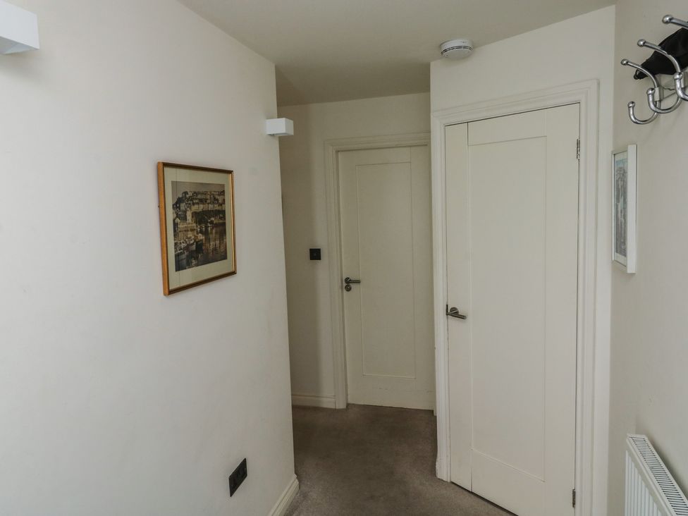 A hallway with a picture on the wall and doors at Bay View in Brixham
