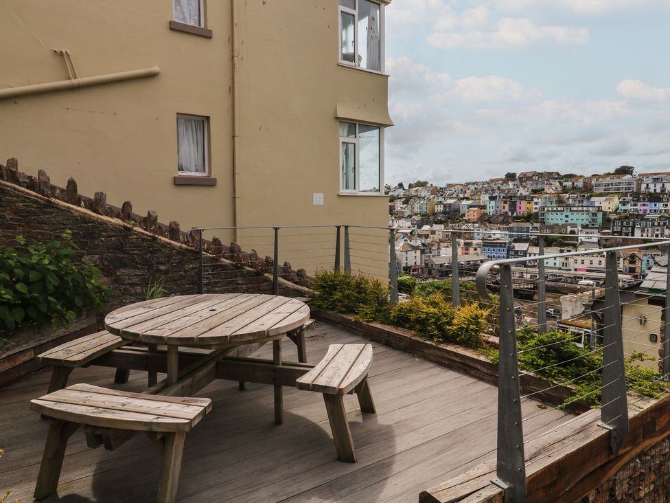 A wooden table and bench seats on a patio at Bay View in Brixham
