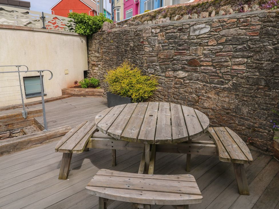 An outdoor area with a wooden table and benches at Bay View in Brixham