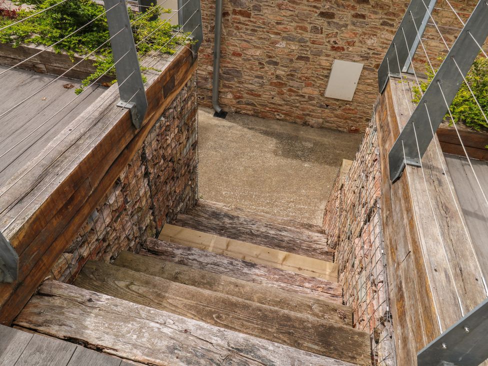 Stairs leading down with wooden steps and stone wall at Bay View in Brixham