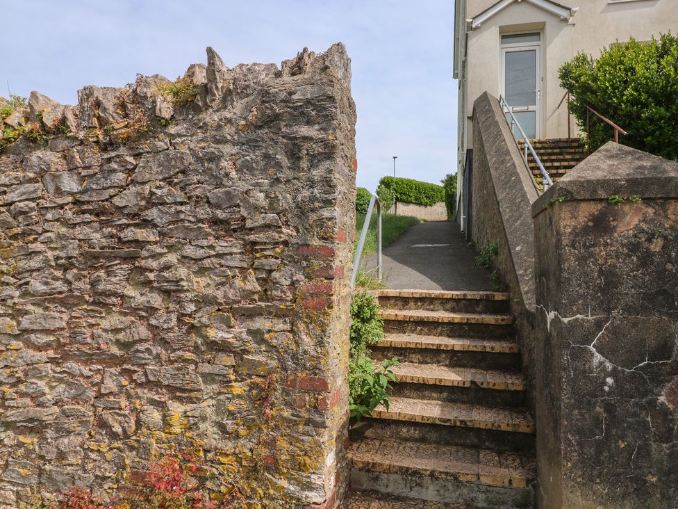 A stairway leading to a building with a stone wall at Bay View in Brixham