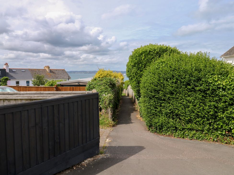 A pathway between hedges with houses in the background at Bay View in Brixham