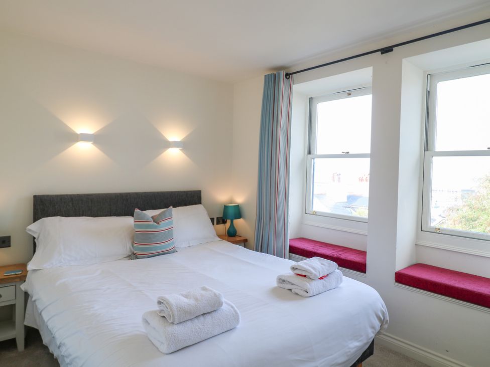 A bedroom with a bed and bedside table at Bay View in Brixham