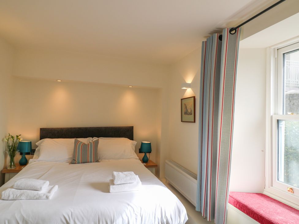 A bedroom with a bed and bedside tables at Bay View in Brixham