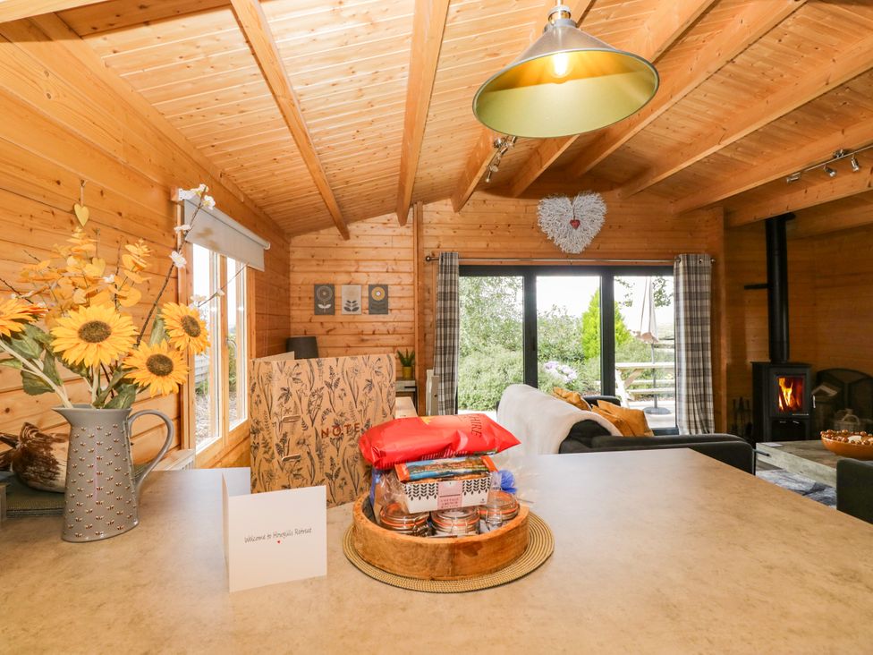 A living room with flowers and a fireplace at Howgills Retreat, Gatebeck near Kirkby Lonsdale