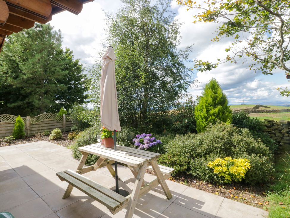 A garden with a table and umbrella at Howgills Retreat Gatebeck near Kirkby Lonsdale
