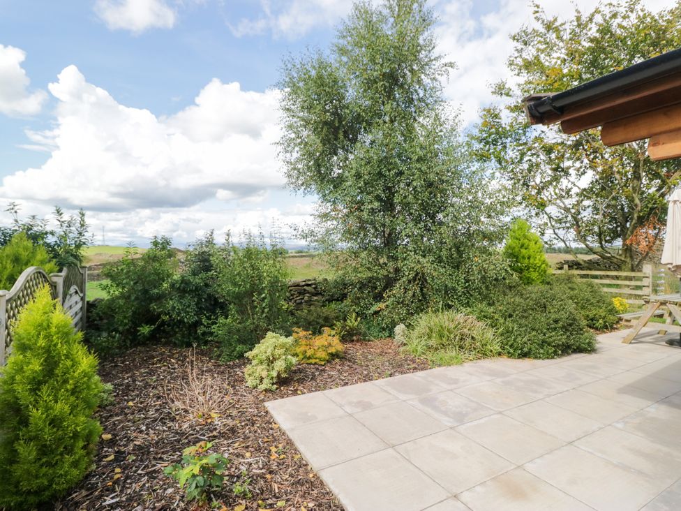 A garden with a patio and various plants at Howgills Retreat Gatebeck near Kirkby Lonsdale