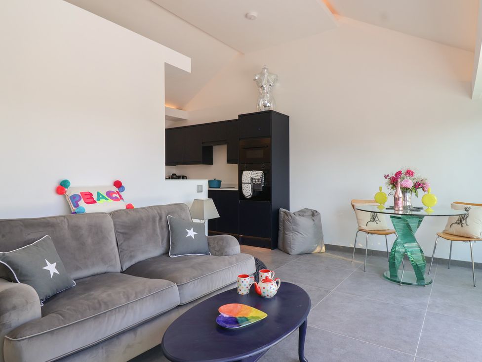 A living room with a sofa and a kitchen area at Ninky Nonk in Bristol