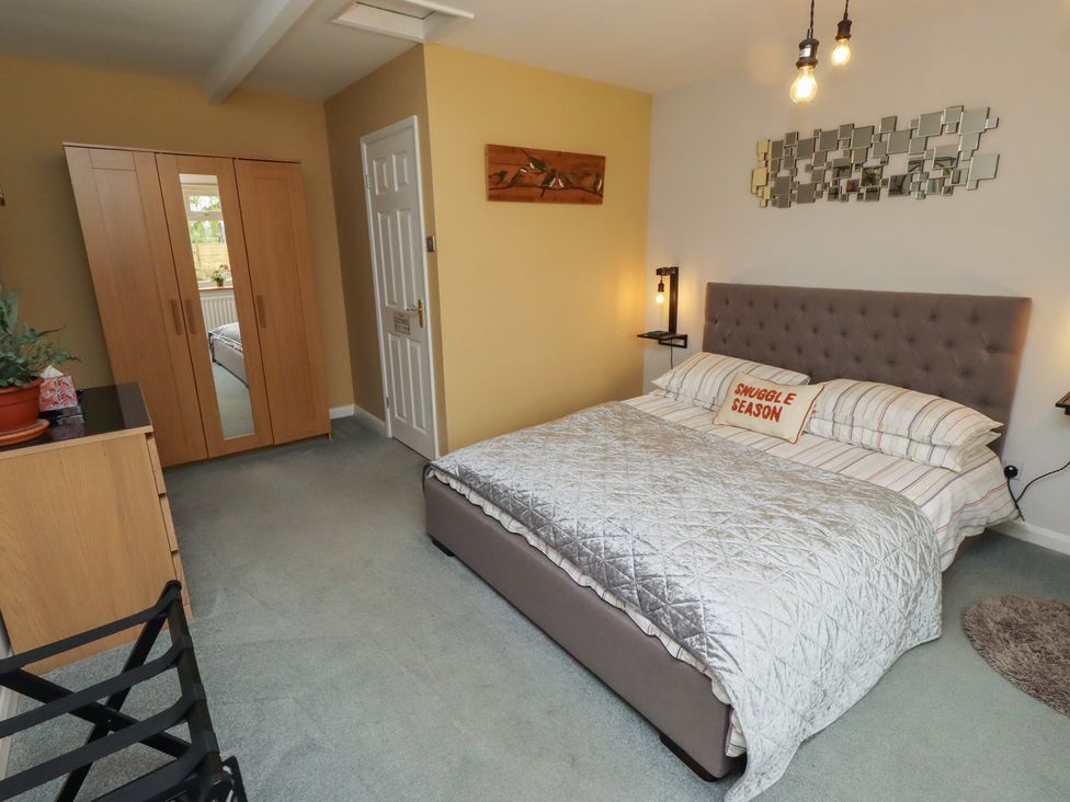 A bedroom with a bed and wardrobe at Country Retreat in Ponteland