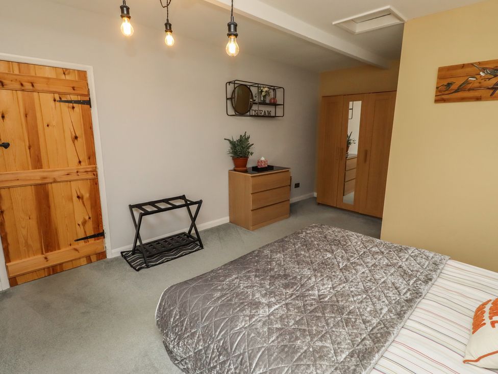 A bedroom with a bed, wardrobe, and a plant at Country Retreat in Ponteland