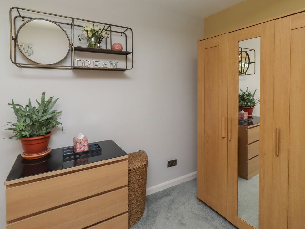A bedroom with a wardrobe and dresser at Country Retreat in Ponteland