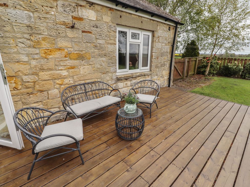 An outdoor seating area with chairs and a coffee table at Country Retreat in Ponteland