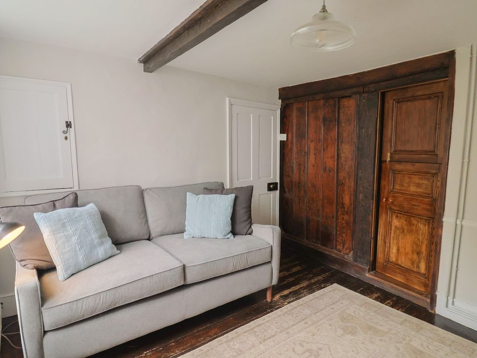A living room with a sofa and wooden cabinet at The Nest in Lyme Regis