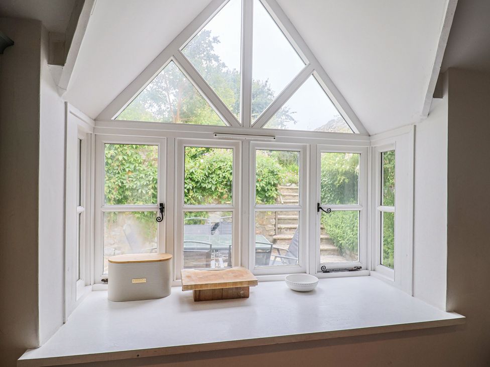 A kitchen window with a cutting board and bowl at The Nest in Lyme Regis