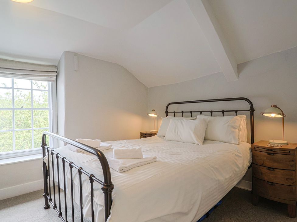 A bedroom with a bed and bedside tables at The Nest in Lyme Regis