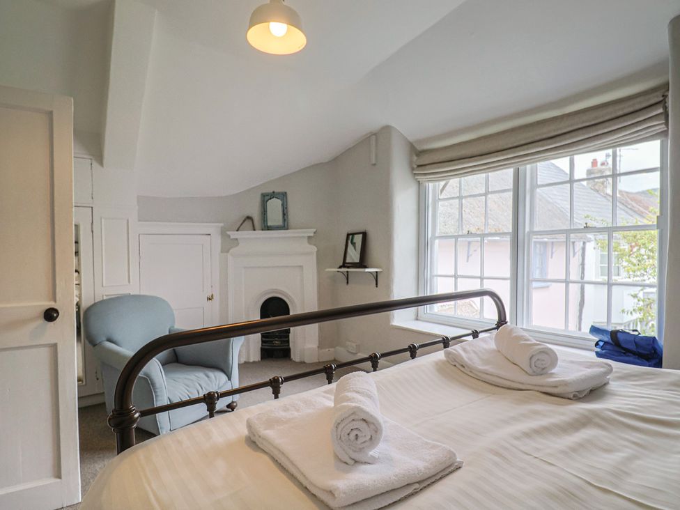 A bedroom with a bed and armchair at The Nest in Lyme Regis