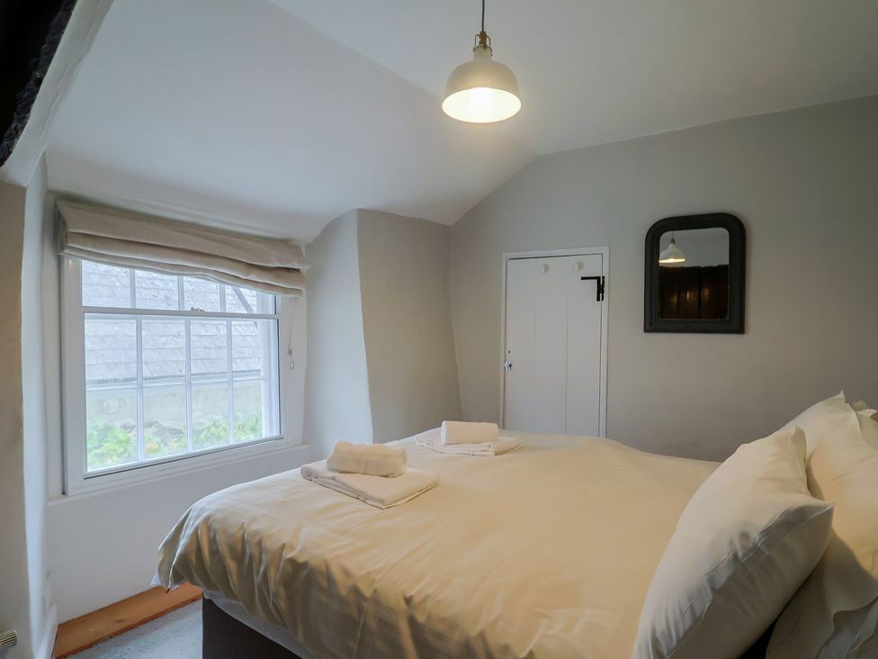 A bedroom with a bed and window at The Nest in Lyme Regis