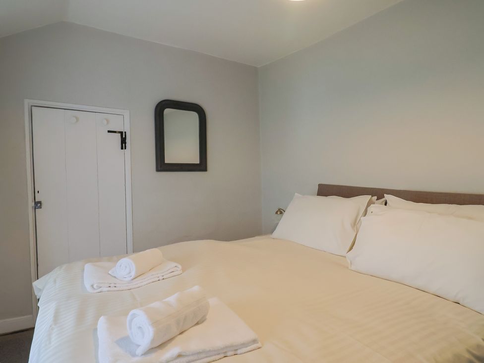 A bedroom with a bed and towels at The Nest in Lyme Regis