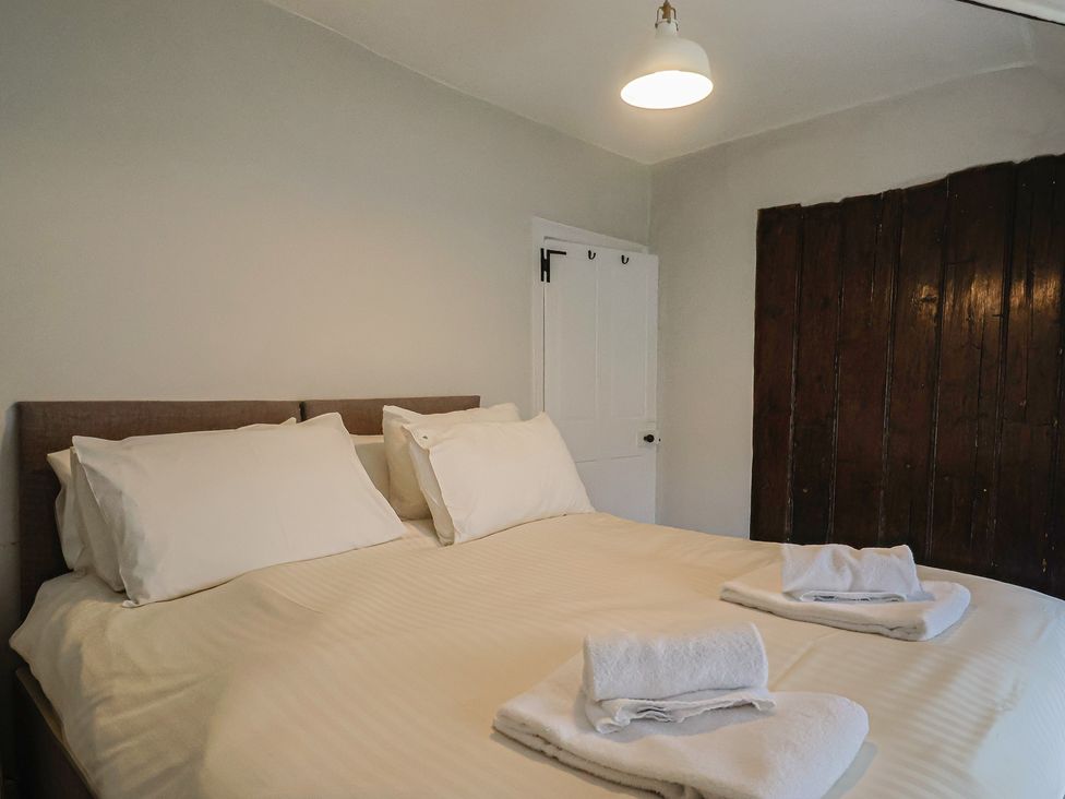A bedroom with a bed and towels at The Nest in Lyme Regis