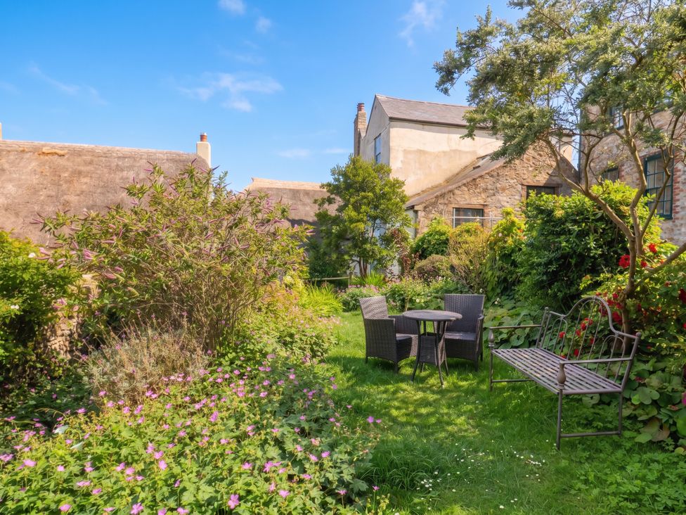 A garden with a table and chairs at The Nest in Lyme Regis