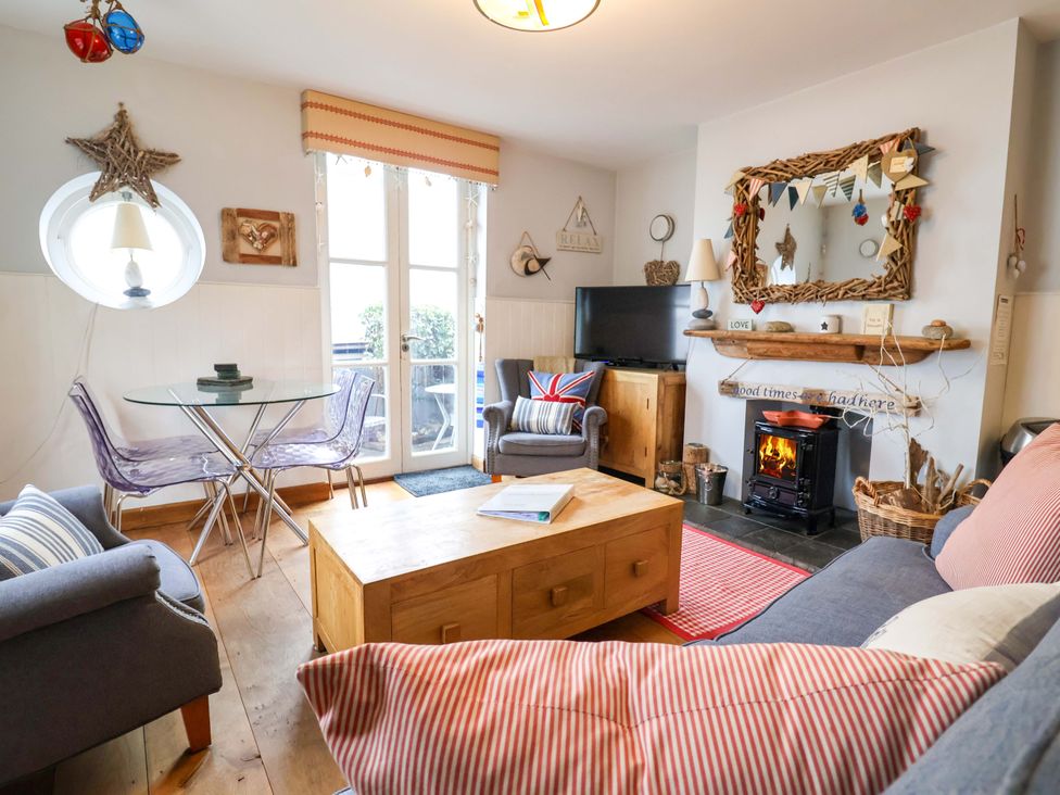 A living room with a sofa, coffee table, and television at Seaside in Lyme Regis