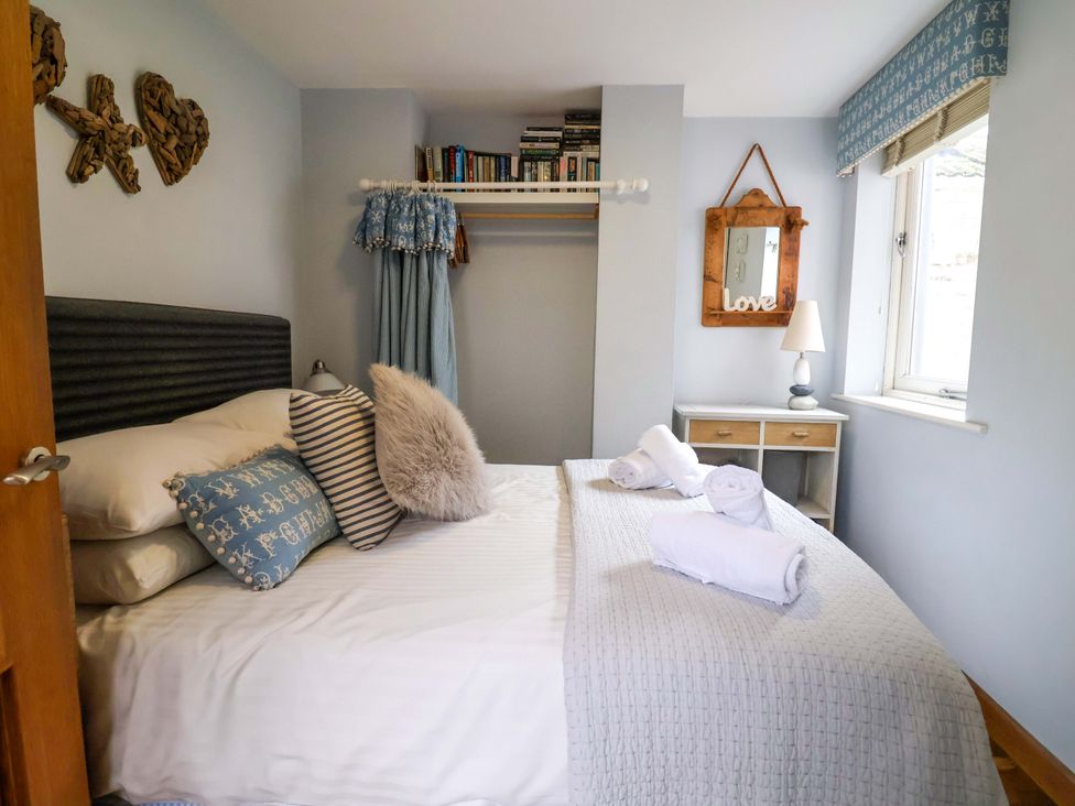 A bedroom with a bed and shelving at Seaside in Lyme Regis