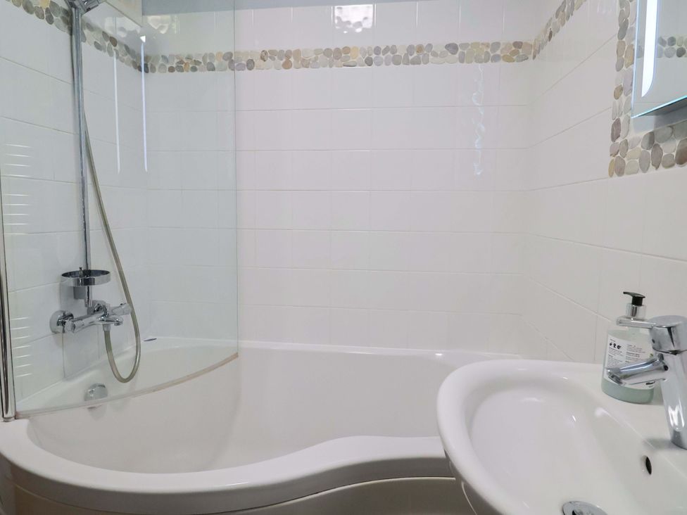 A bathroom with a bathtub and shower at Seaside in Lyme Regis