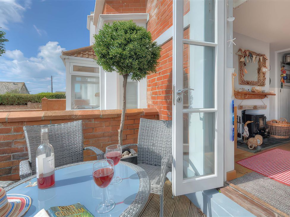 An outdoor seating area with a table and wine glasses at Seaside in Lyme Regis