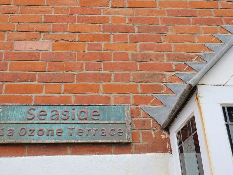 A wall with a house sign at Seaside in Lyme Regis