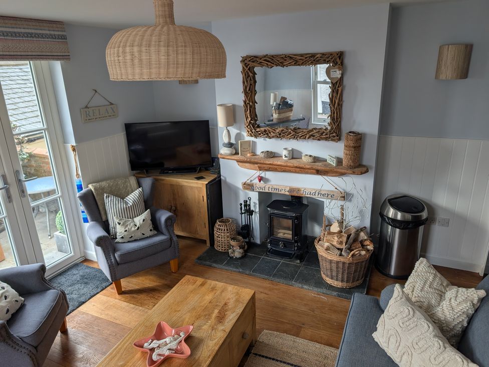A living room with a fireplace and television at Seaside in Lyme Regis