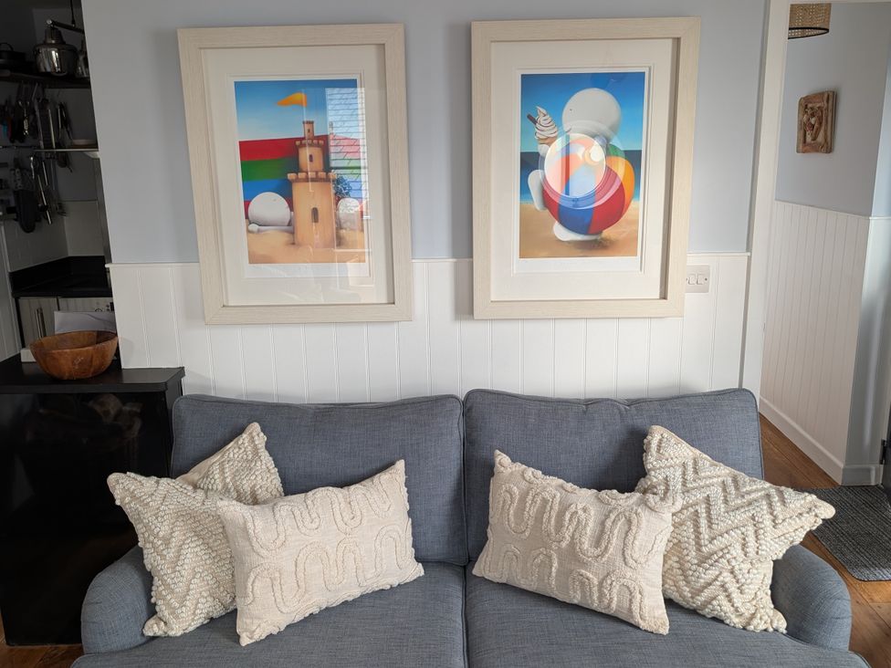 A living room with artwork above a sofa at Seaside in Lyme Regis