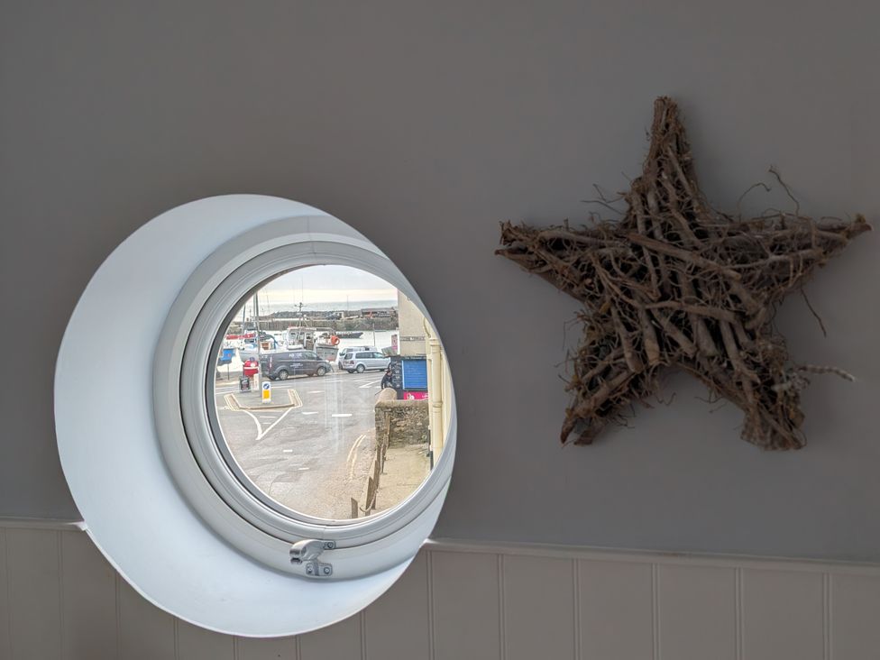 A window view of a street with vehicles and boats at Seaside Lyme Regis