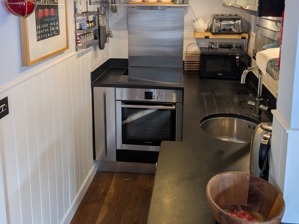A kitchen with an oven, sink, and various appliances at Seaside in Lyme Regis