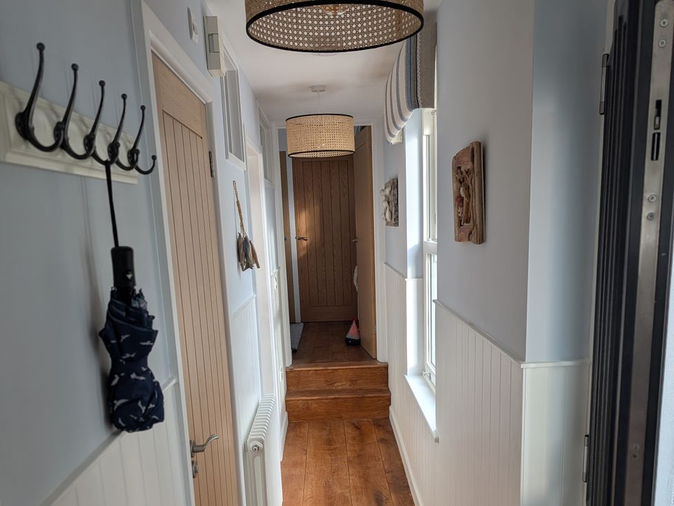 A hallway with coat hooks and a door at Seaside in Lyme Regis