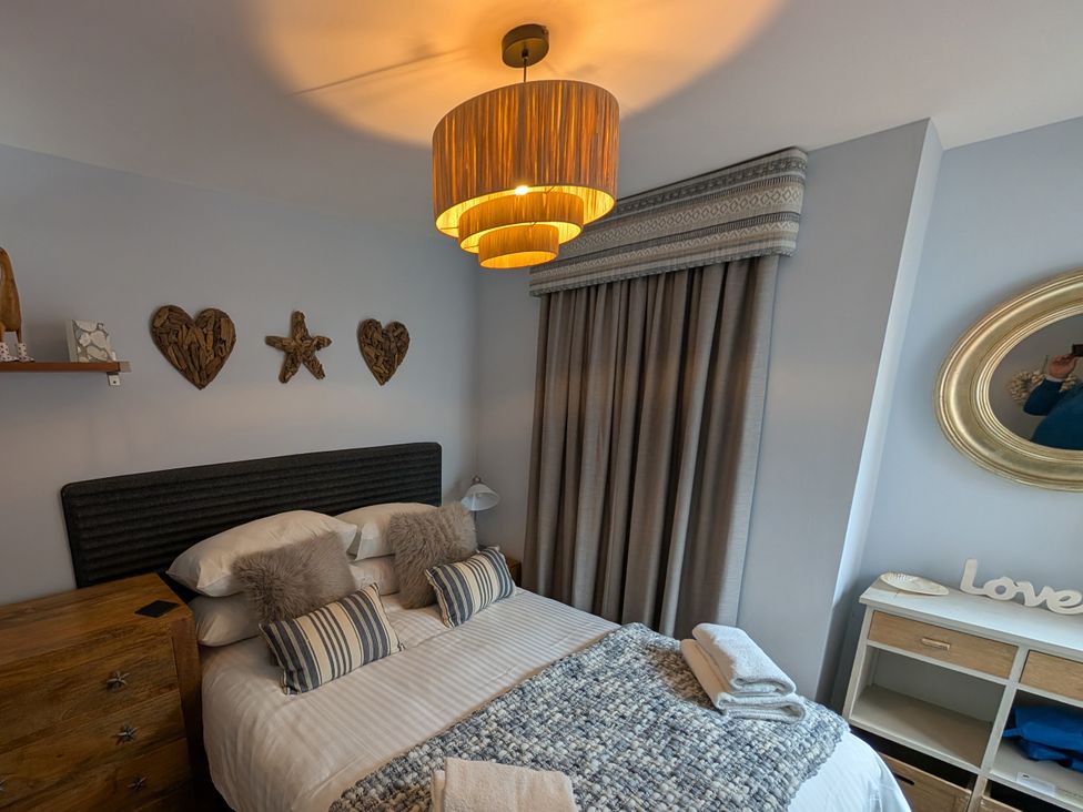 A bedroom with a bed and decorative items at Seaside in Lyme Regis
