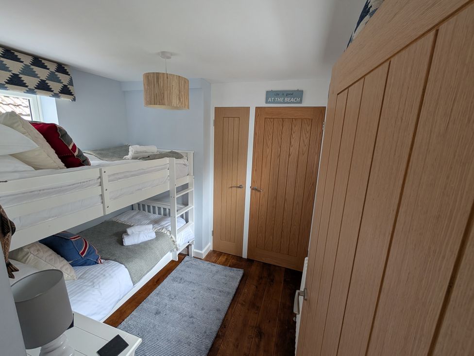 A bedroom with a bunk bed and lamp at Seaside in Lyme Regis