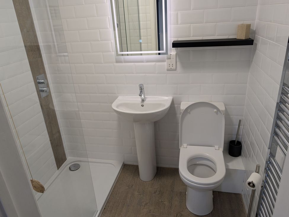 A bathroom with a shower, sink, and toilet at Seaside in Lyme Regis