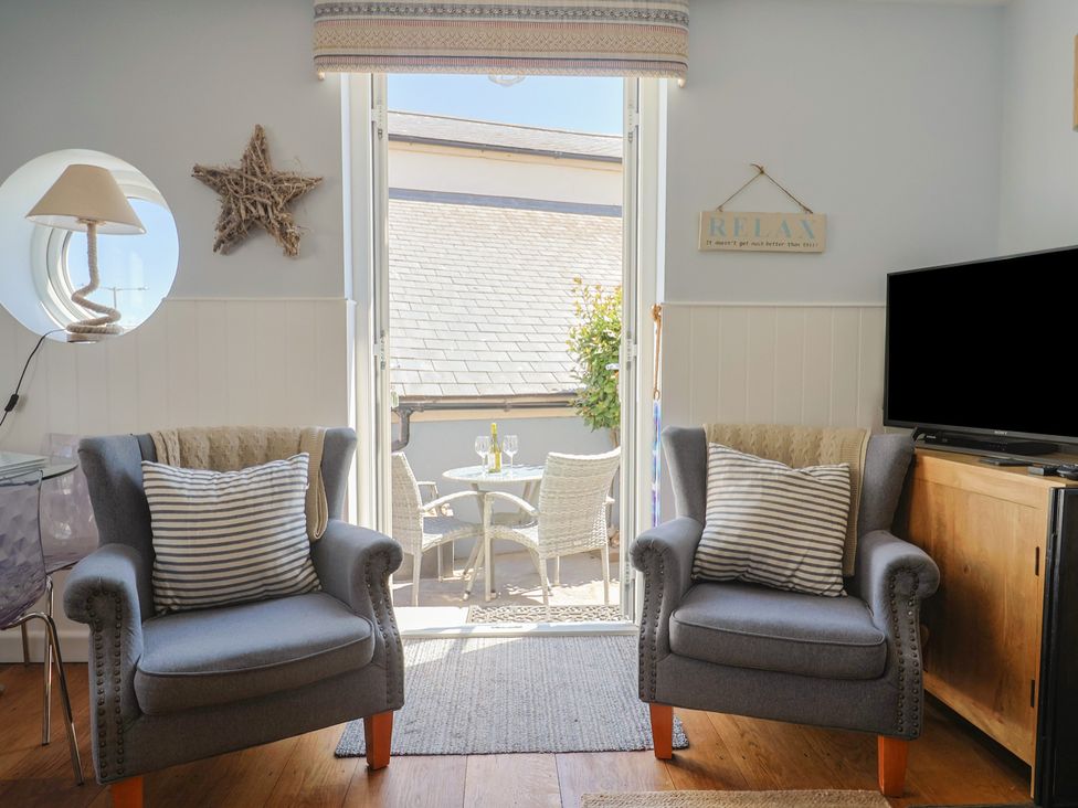 A living room with chairs and a television at Seaside in Lyme Regis